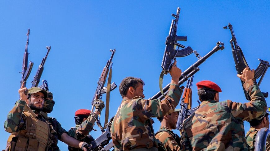 Huthi fighters brandish weapons as they rally during an anti-Israel and anti-US rally in Yemen's Huthi-controlled capital Sanaa on January 22, 2024