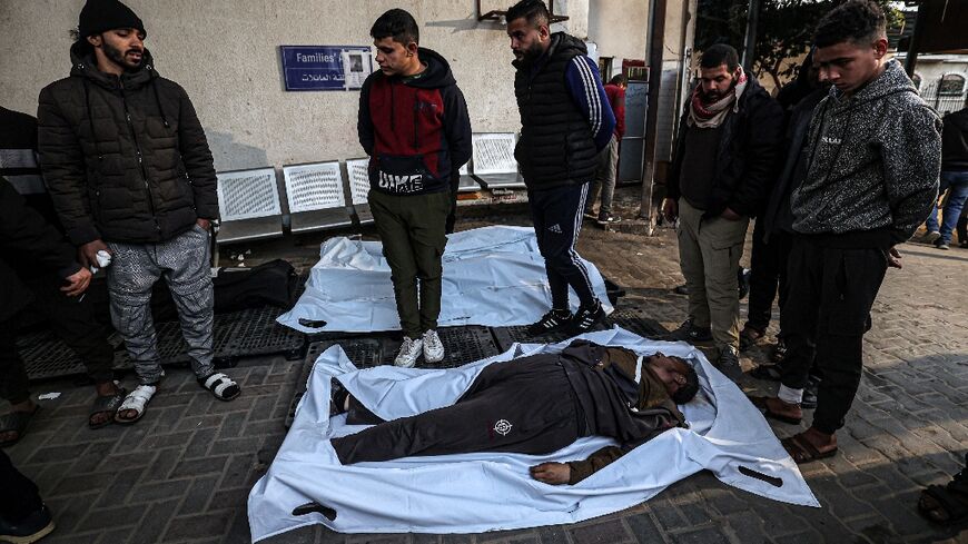 Corpses of people killed in Israeli bombing are lined up outside the morgue of Al-Najjar hospital in Rafah, the southern Gaza Strip 