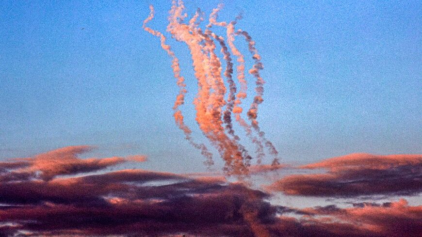 Smoke plumes trail from a salvo of rockets fired towards Israel, pictured from the southern Gaza Strip