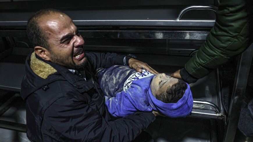 A relative  at the European hospital in Khan Yunis mourns over the body of a 12-year-old boy killed along with his immediate family during Israeli bombardment