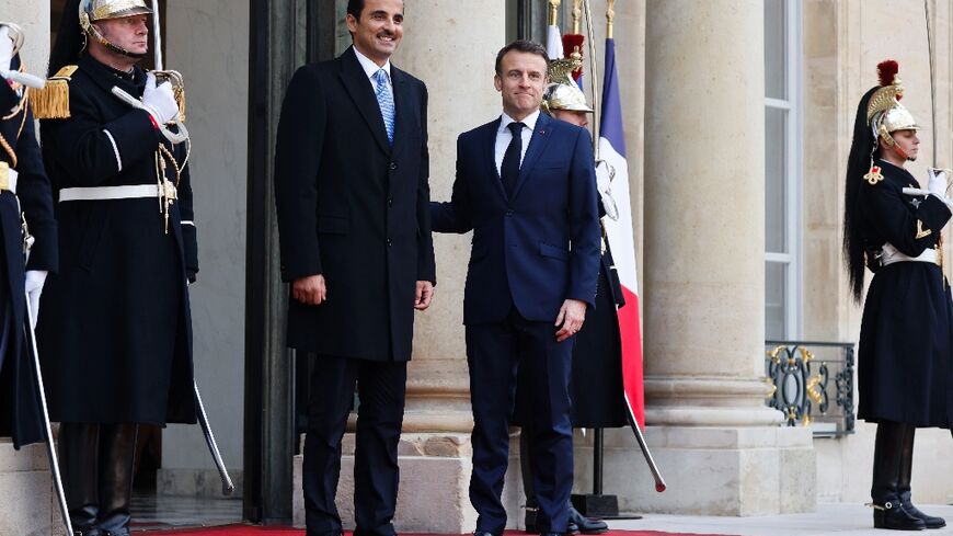 French President Emmanuel Macron greets Qatar's Emir Sheikh Tamim bin Hamad al-Thani at the Elysee Palace before talks dominated by the Gaza war