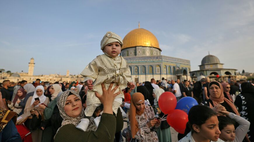 TOPSHOT - Muslims celebrate in front of the Dome of the Rock mosque after the morning Eid al-Fitr prayer, which marks the end of the holy fasting month of Ramadan, at the Al-Aqsa mosques compound in Old Jerusalem early on May 2, 2022. (Photo by AHMAD GHARABLI / AFP) (Photo by AHMAD GHARABLI/AFP via Getty Images)