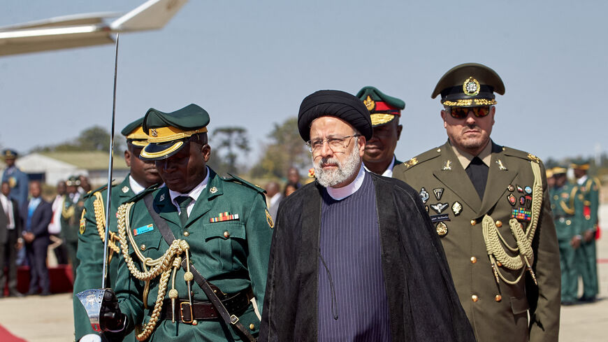 Iranian President Ebrahim Raisi (C) inspects the guard of honour upon his arrival for a state visit at the Robert Gabriel Mugabe International Airport in Harare on July 13, 2023. (Photo by Jekesai NJIKIZANA / AFP) (Photo by JEKESAI NJIKIZANA/AFP via Getty Images)