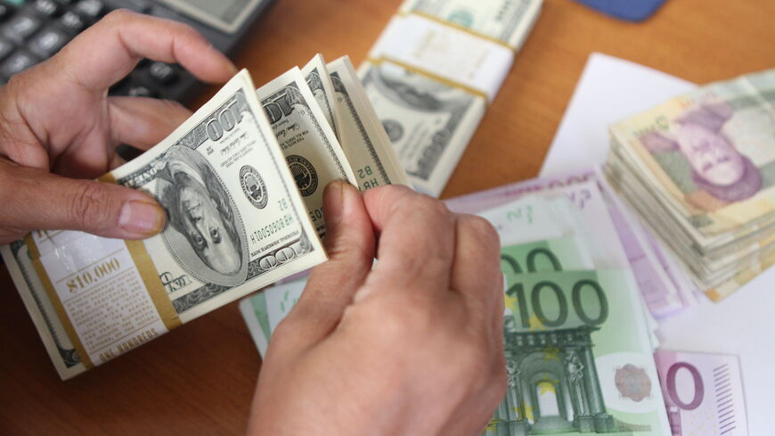 The picture illustrates euro and United States 100-dollar banknotes bearing the portrait of US statesman, inventor and diplomat Benjamin Franklin next to Iran's rial banknotes, bearing a portrait of Iran's late founder of Islamic Republic Ayatollah Ruhollah Khomeini in Tehran on September 30, 2012. Iran's currency, the rial, dived to a new low of around 29,600 to the dollar in open trading, losing over 60 percent of its value since the end of last year according to exchange tracking websites as draconian We