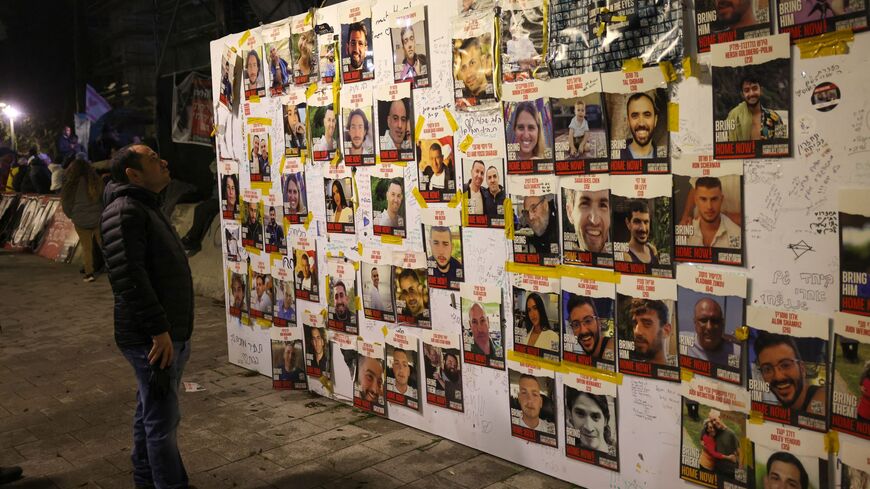 People look at portraits of Israeli hostages held in Gaza since the October 7 attacks by Palestinian Hamas militants, as relatives and supporters rally calling for their release in Tel Aviv on February 3, 2024.