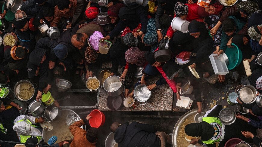 Palestinians receive food rations at a donation point at a camp for internally displaced people in Rafah 