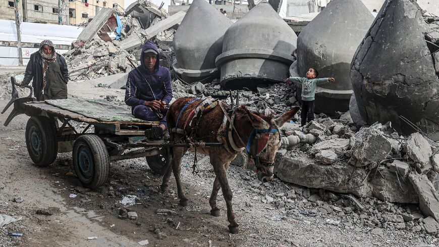 A donkey-pulled cart passes the rubble of Al-Faruq Mosque, destroyed during Israeli bombardment in Rafah, the southern Gaza Strip, where Israel says it will send in ground troops