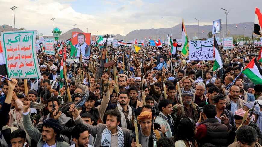 Yemenis brandish weapons as they march in the Huthi-run capital Sanaa in support of Palestinians and Hamas