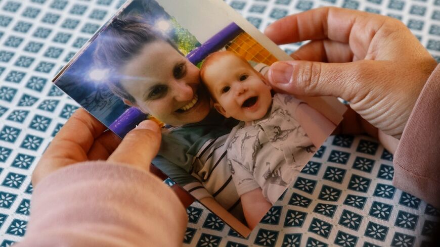 A relative of Shiri Bibas, an Israeli woman kidnaped during the October 7 attack, holds a snapshot of her and one of her two boys