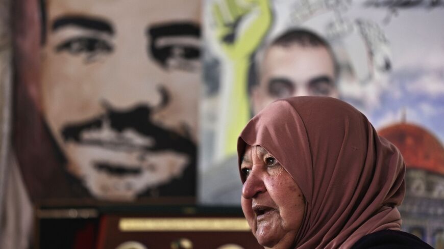 Latifa Abu Hamid, 74, sits near portraits of her children, at her house in Ramallah in the occupied West Bank