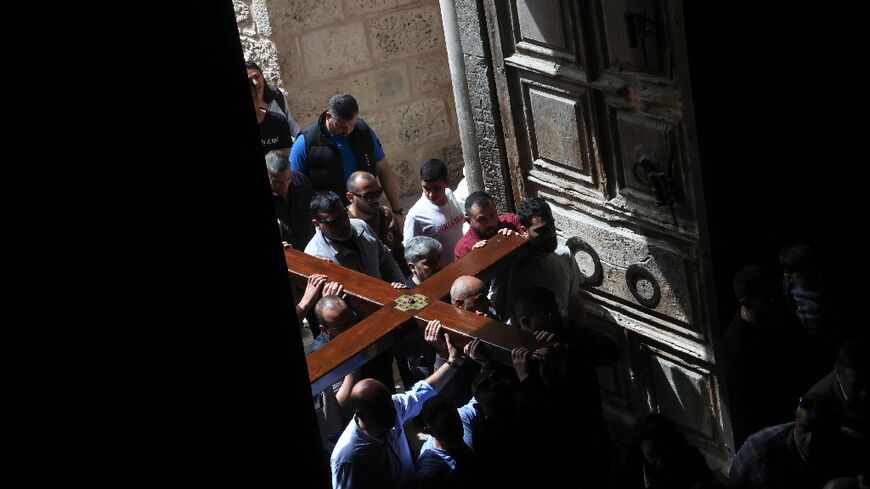 Christian pilgrims carry a wooden cross on the Good Friday procession through the streets of the Old City of Israeli-annexed east Jerusalem