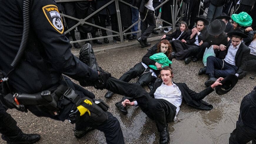 Israeli police officers try to remove ultra-Orthodox Jews protesting against defence ministry plans to end their longstanding exemption from  compulsory military service