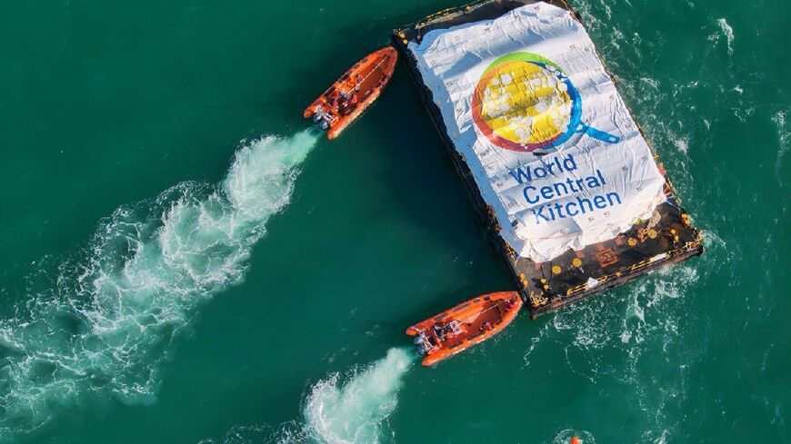 This picture released by the Israeli army shows a barge laden with food for Gaza being pushed towards a makeshift jetty for unloading after it was towed from Cyprus in a trial run for a new maritime aid corridor