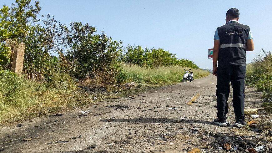 A Lebanese intelligence agent surveys the surroundings at the scene of an Israeli drone strike north of the coastal city of Tyre