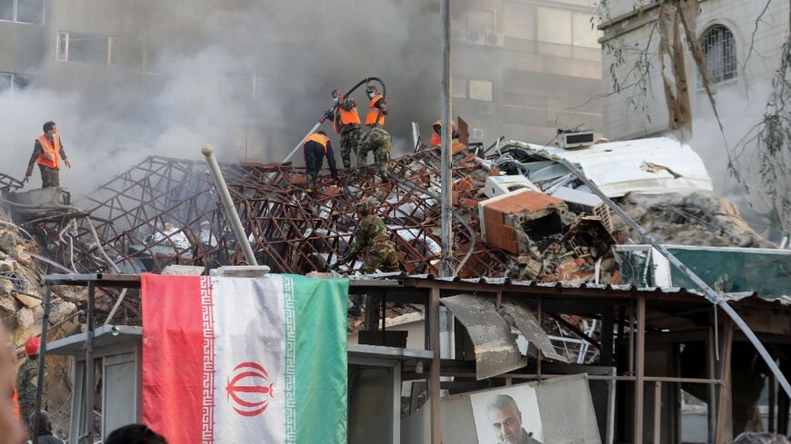 An Iranian flag is draped over the railings outside the flattened consular annex of the Iranian embassy in Damascus