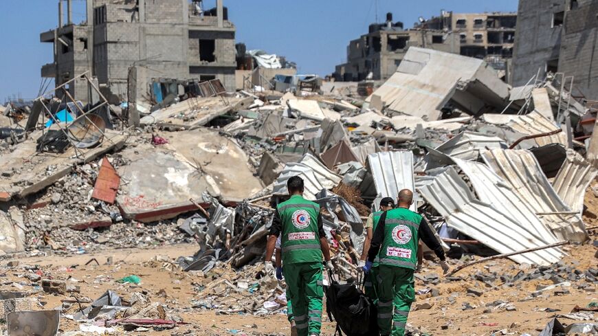 Palestinian paramedics carry away bodies of dead people uncovered in the vicinity of Al-Shifa hospital in Gaza City