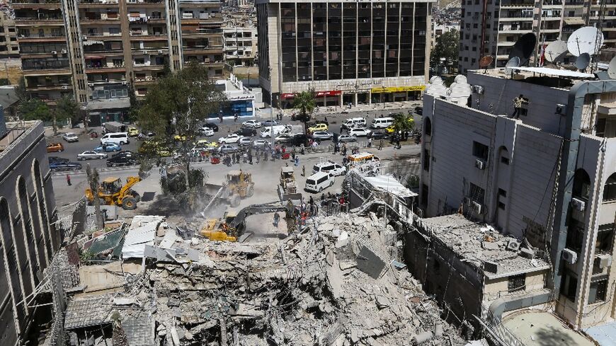 Rescue workers search in the rubble of a building annexed to the Iranian embassy in Damascus 