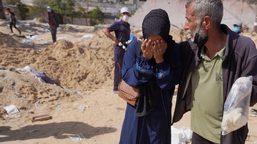 Palestinians react after the body of a relative was found buried at the Nasser hospital in southern Gaza