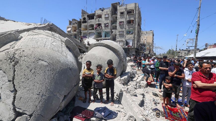 Palestinians pray next to the ruins of Al-Farooq Mosque, destroyed during Israeli bombardment in Rafah