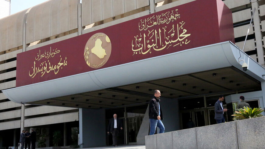 Iraqis stand outside parliament building, or Council of Representatives, in the Green Zone, Baghdad, Iraq, Feb. 27, 2020. 