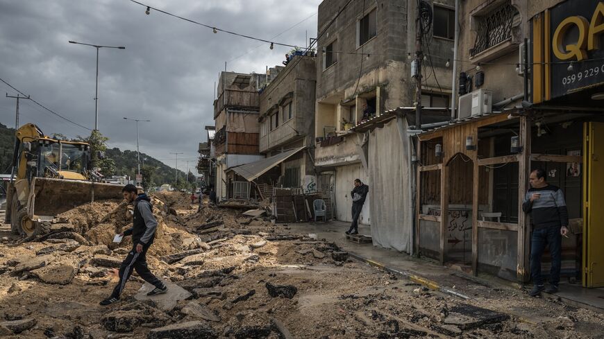 Palestinians survey a destroyed pavement following an Israeli raid in the Nur Shams camp near Tulkarm on March 4, 2024, West Bank.