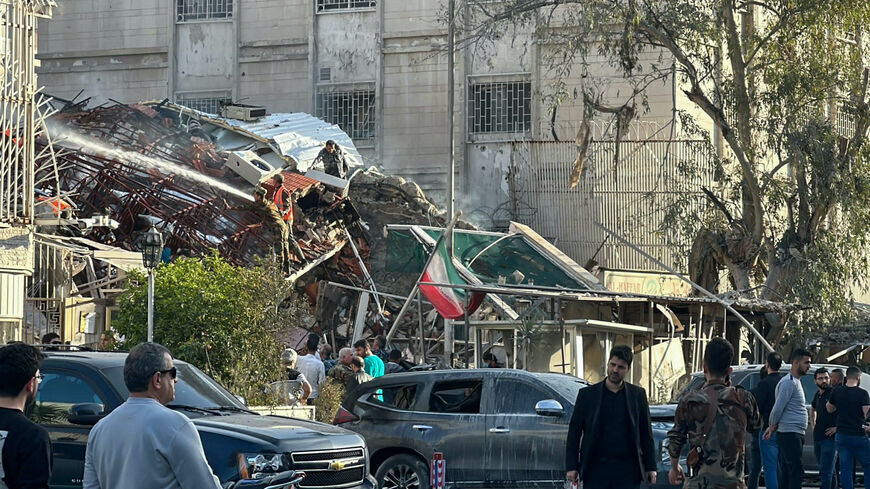 Emergency and security personnel gather at the site of strikes which hit a building next to the Iranian embassy in Syria's capital Damascus, on April 1, 2024.