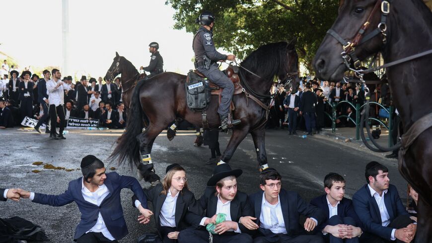 Ultra Orthodox Jewish youths block a road in Bnei Brak as they protest against their conscription into the Israeli armed forces, on April 1, 2024.