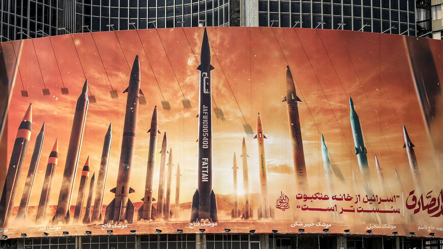 This picture taken on April 15, 2024 shows a view of a billboard depicting named Iranian ballistic missiles in service, with text in Arabic reading "the honest [person's] promise" and in Persian "Israel is weaker than a spider's web", in Valiasr Square in central Tehran. Iran on April 14 urged Israel not to retaliate militarily to an unprecedented attack overnight, which Tehran presented as a justified response to a deadly strike on its consulate building in Damascus. (Photo by ATTA KENARE / AFP) (Photo by 