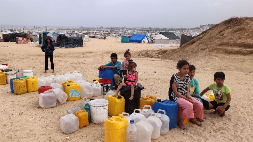 Displaced Palestinian children wait for water at their tent camp in Rafah -- the UN children's agency estimates the war has displaced around 850,000 children in Gaza