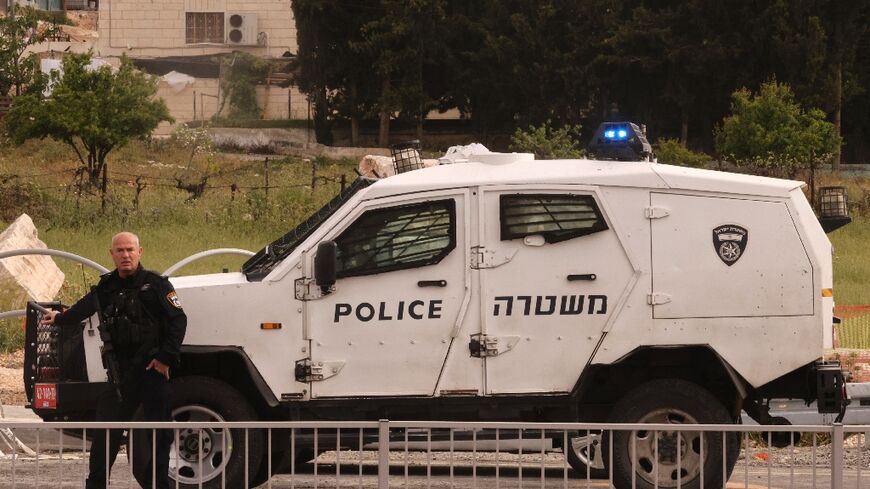 An Israeli policeman cordons off the Beit Einun junction area, after the latest deadly incident in the Israeli-occupied West Bank