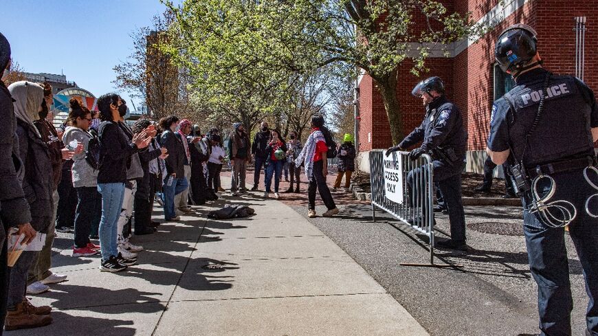 Pro-Palestinian protesters stand in front of a police barricade after police raided an encampment at Northeastern University in Boston, Massachusetts, on April 27, 2024