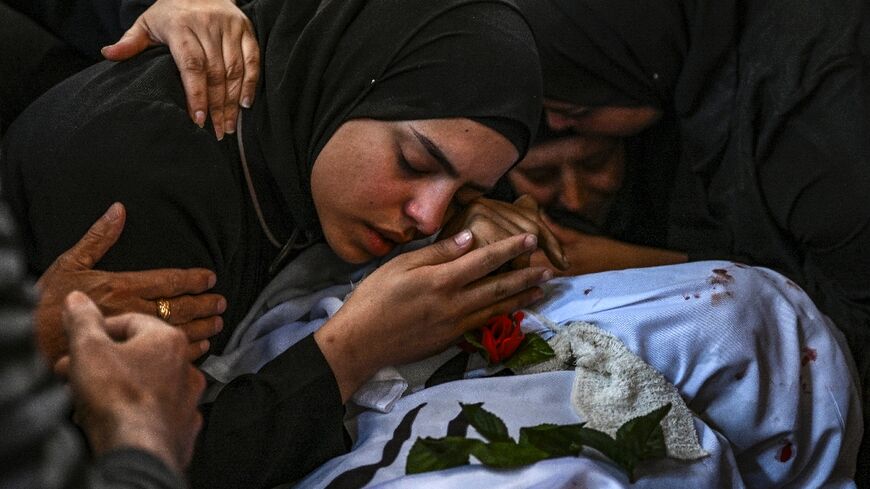 A funeral procession for 13 Palestinians killed in the Israeli army raid passed through roads piled with rubble