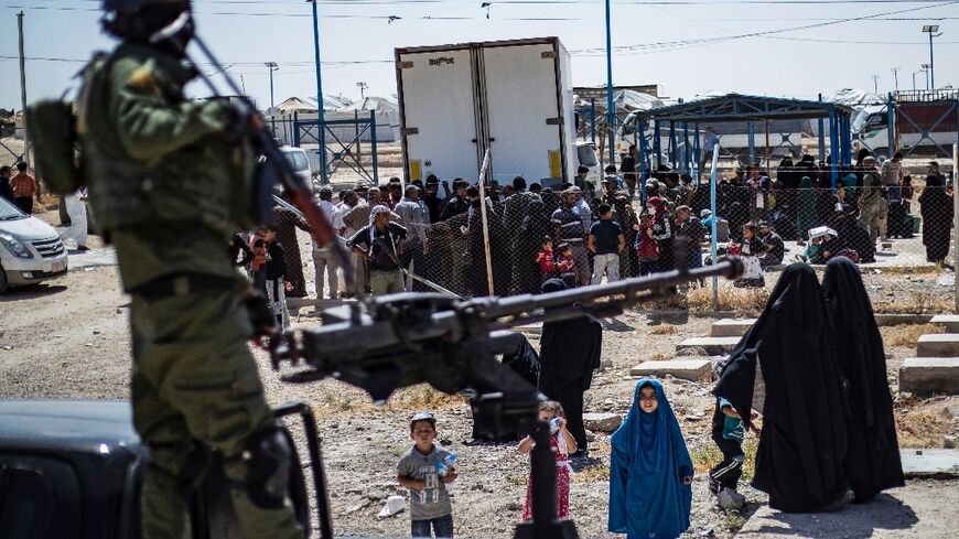 Kurdish security forces in northeastern Syria guard the entrance of the Al-Hol camp during a release of relatives of suspected Islamic State group fighters last year