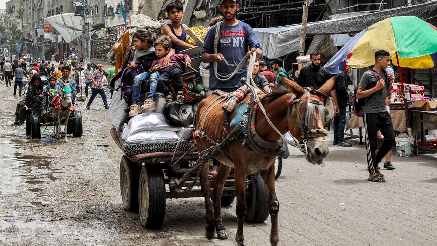 A man flees with children and belongings from the Jabalia camp for Palestinian refugees in the northern Gaza Strip on May 11, 2024 