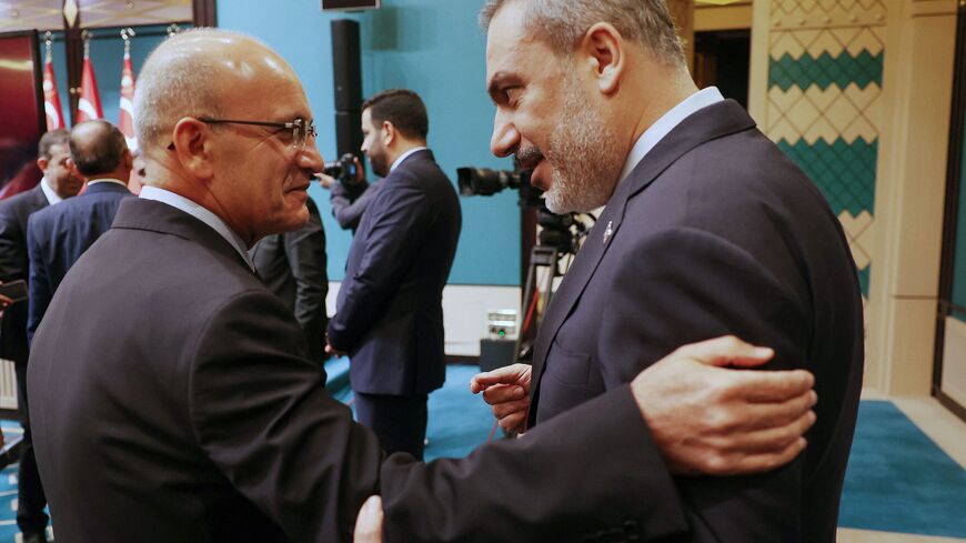 Turkish Treasury and Finance Minister Mehmet Simsek (L) speak with Turkish Foreign Minister Hakan Fidan (R) before the press conference following the cabinet meeting held at the Presidential Complex in Ankara on August 21, 2023. (Photo by Adem ALTAN / AFP) (Photo by ADEM ALTAN/AFP via Getty Images)