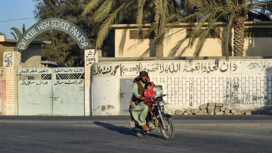 A motorcyclist rides past a high school at Panjgur district in Balochistan province on Jan. 17, 2024.