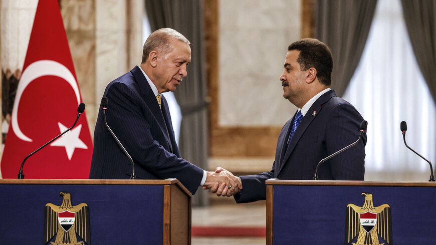 Iraq's Prime Minister Mohammed Shia al-Sudani (R) and Turkey's President Recep Tayyip Erdogan shake hands after a joint statement to the media in Baghdad on April 22, 2024.