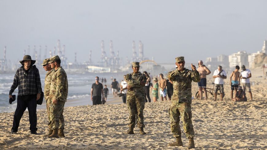 A US soldier gives the thumbs-up as an Israeli digger attempts to extricate a US military vessel.