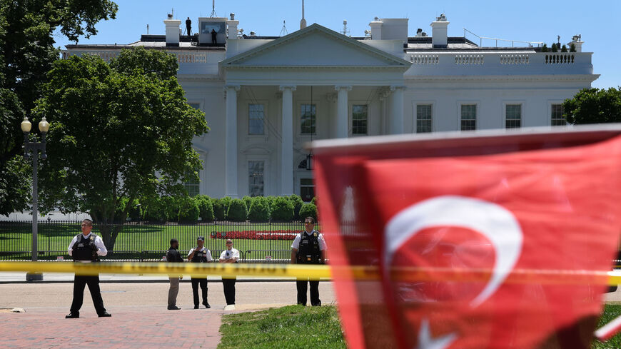 Members of the Secret Service stand guard as people wave Turkish flags during a rally in front of the White House in Washington,DC on May 16, 2017.