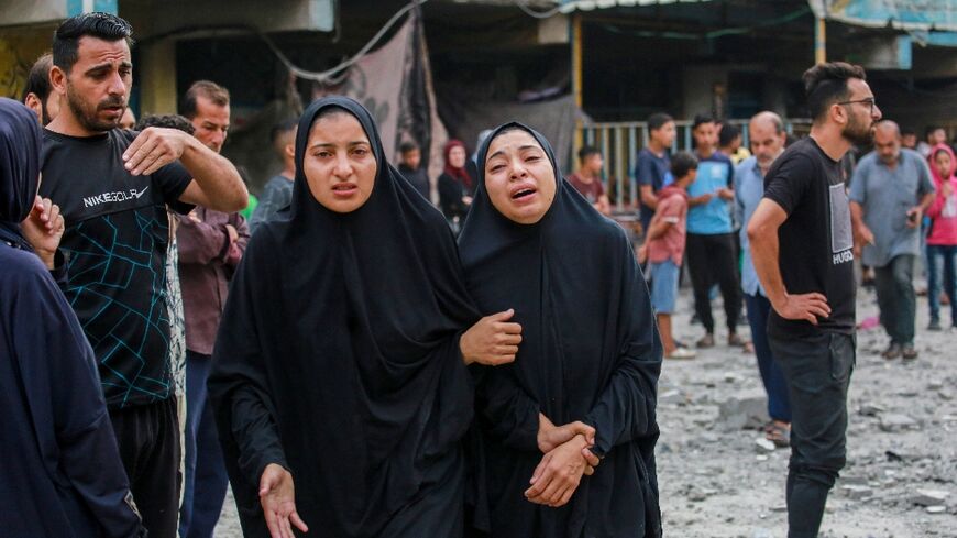 Palestinians at a UN-run school hit during Irsaeli bombradment in central Gaza's Nuseirat