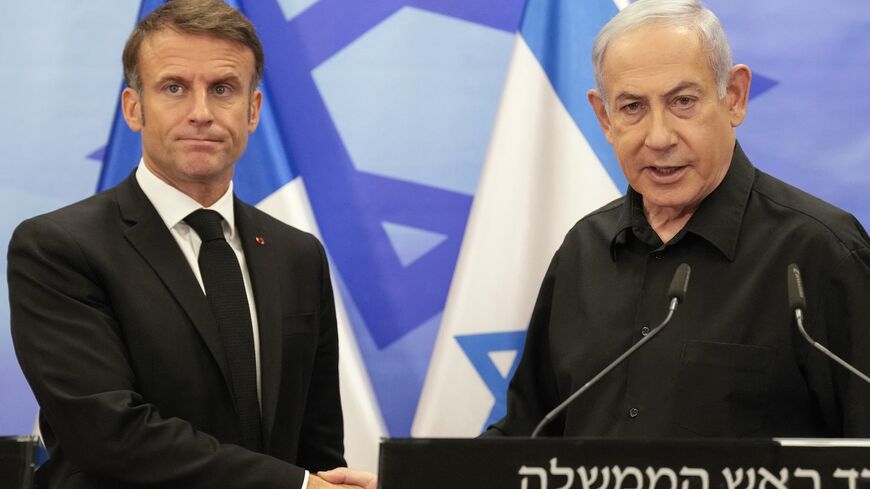 Israeli Prime Minister Benjamin Netanyahu (R) shakes hands with French President Emmanuel Macron (L).