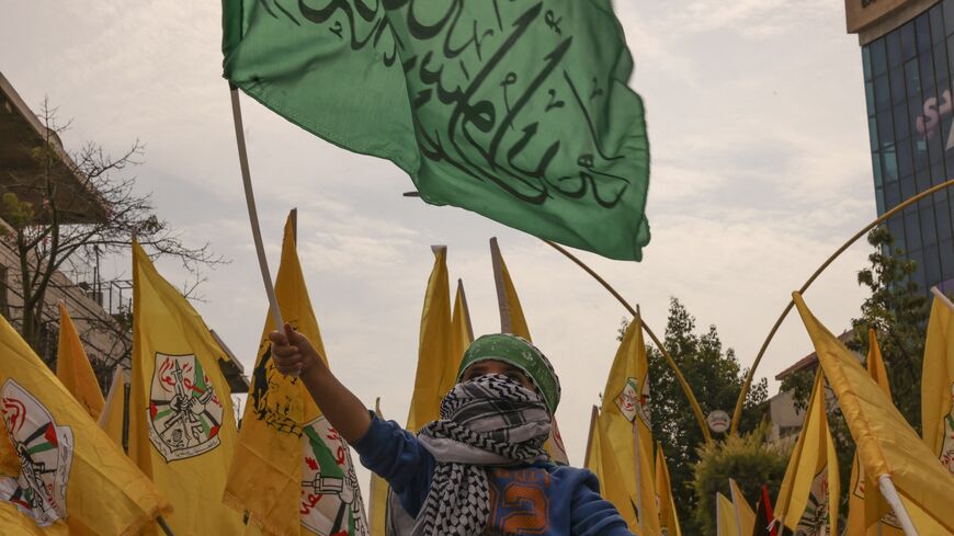 A child waves the flag of Hamas as others wave the Fatah emblem during a solidarity march with the Palestinians of the Gaza Strip in the occupied West Bank city of Hebron on Oct. 27, 2023.