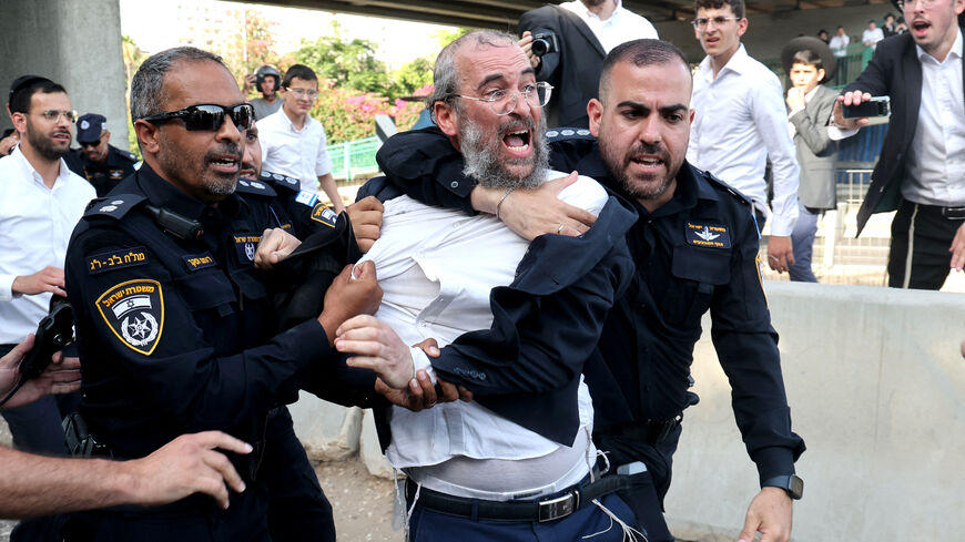 Israeli police disperse Ultra-Orthodox Jews blocking a highway during a protest against possible changes regarding the laws on the military draft from which the Ultra-Orthodox community has traditionally been exempt, in the central Israeli city of Bnei Brak, on June 20, 2024, amid the ongoing conflict between Israel and the Palestinian Hamas militant group. (Photo by JACK GUEZ / AFP) (Photo by JACK GUEZ/AFP via Getty Images)