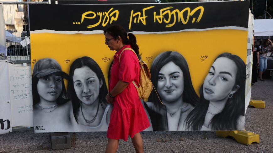 A woman walks past a poster during a demonstration by relatives and supporters of Israelis taken hostage by Palestinian militants in Gaza.