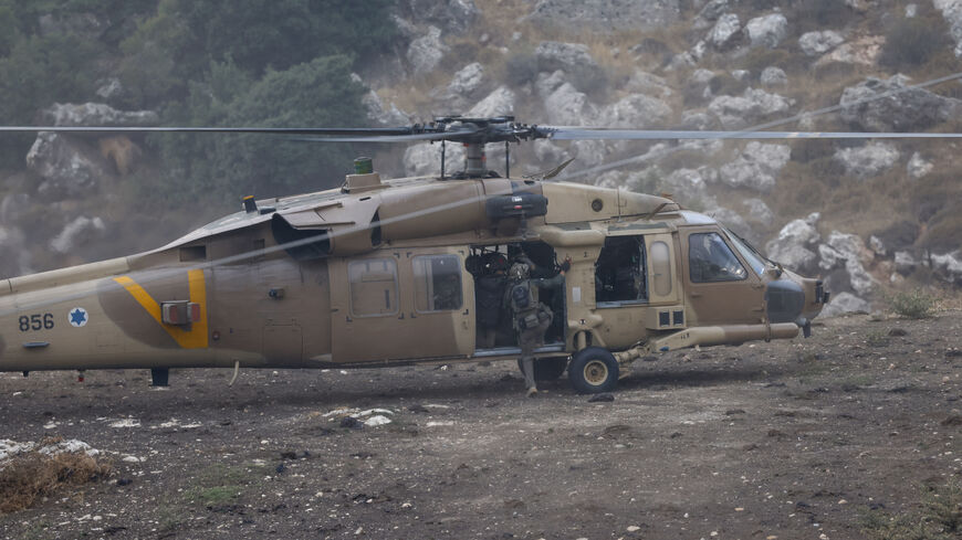 Israeli security forces leave in a helicopter near a site where a reported strike from Lebanon fell in Majdal Shams village in the Israeli-annexed Golan area on July 27, 2024. Israel's emergency medical service Magen David Adom said at least nine people were killed and 34 wounded including 17 in critical condition, after a rocket fired from Lebanon had hit the town of Majdal Shams in the Israeli-annexed Golan Heights. (Photo by Jalaa MAREY / AFP) (Photo by JALAA MAREY/AFP via Getty Images)