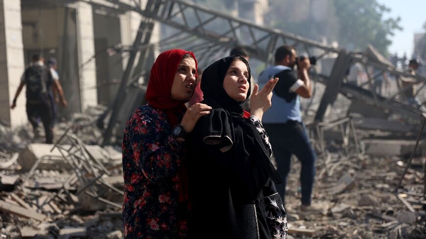 Palestinians look at Gaza City's Holy Family school after it was hit, in the second such Israeli strike in two days