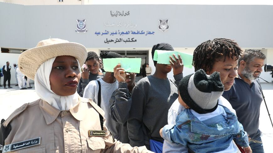 A group of Nigerian migrants being repatriated to their home country from Libya in cooperation with the International Organization for Migration get ready to board a plane at Tripoli airport