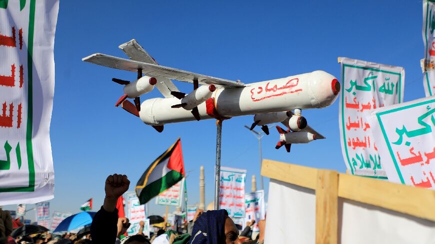 A demonstrator carries a mock drone during a rally in the Huthi-run Yemeni capital Sanaa on February 23, 2024