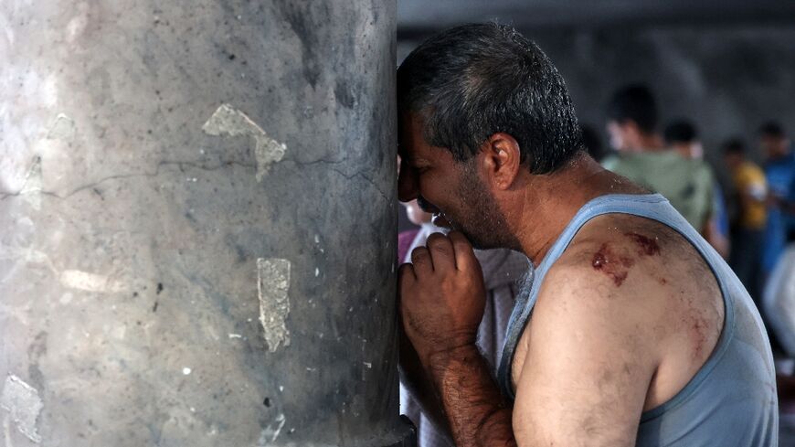 A man cries inside a school used as a temporary shelter for displaced Palestinians in Gaza City, after a deadly Israeli strike 