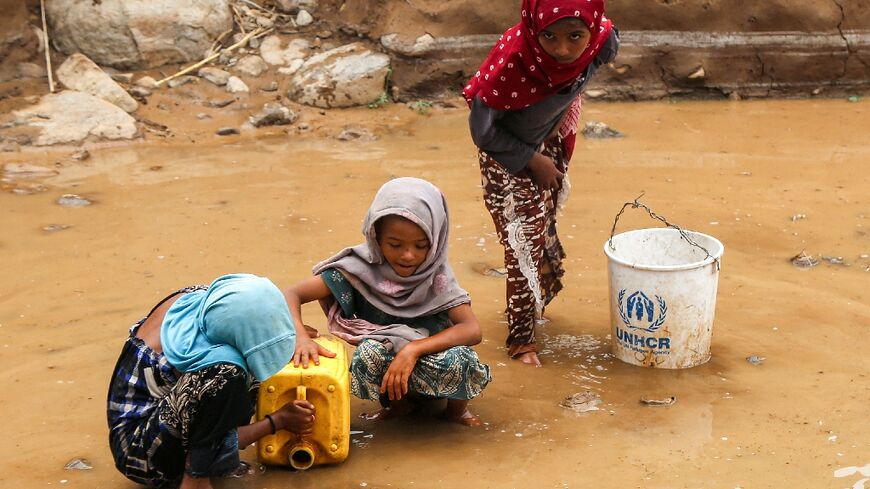 Yemeni children fill a jerrycan with water after flash floods in Hodeida province on the Red Sea coast.